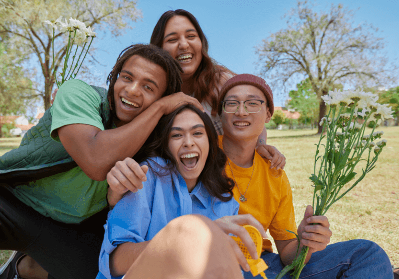 a group of teens hanging out outside on a sunny day