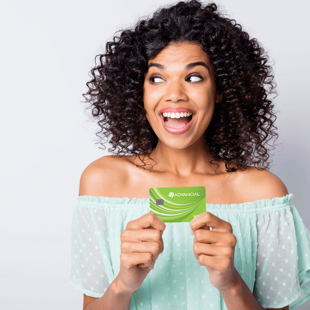 smiling woman holding Advancial's Ultimate Checking debit card